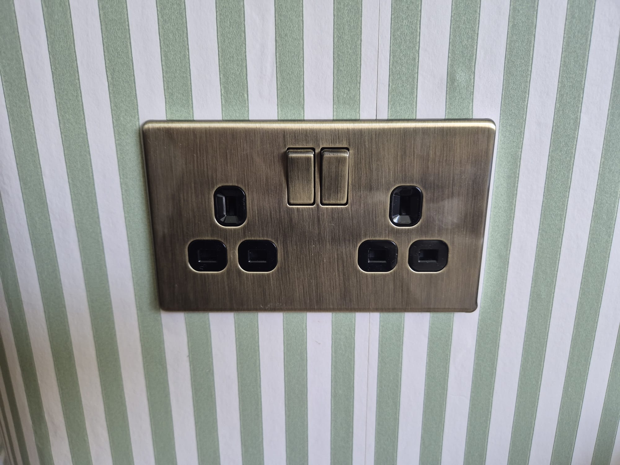 Electrician inspecting a wall socket for damage